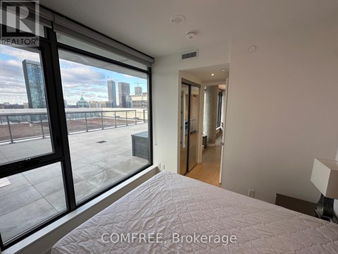 A bedroom with a large bed and a view of the city through the window.