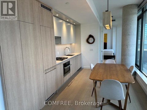 A kitchen with a table and chairs in front of a window.