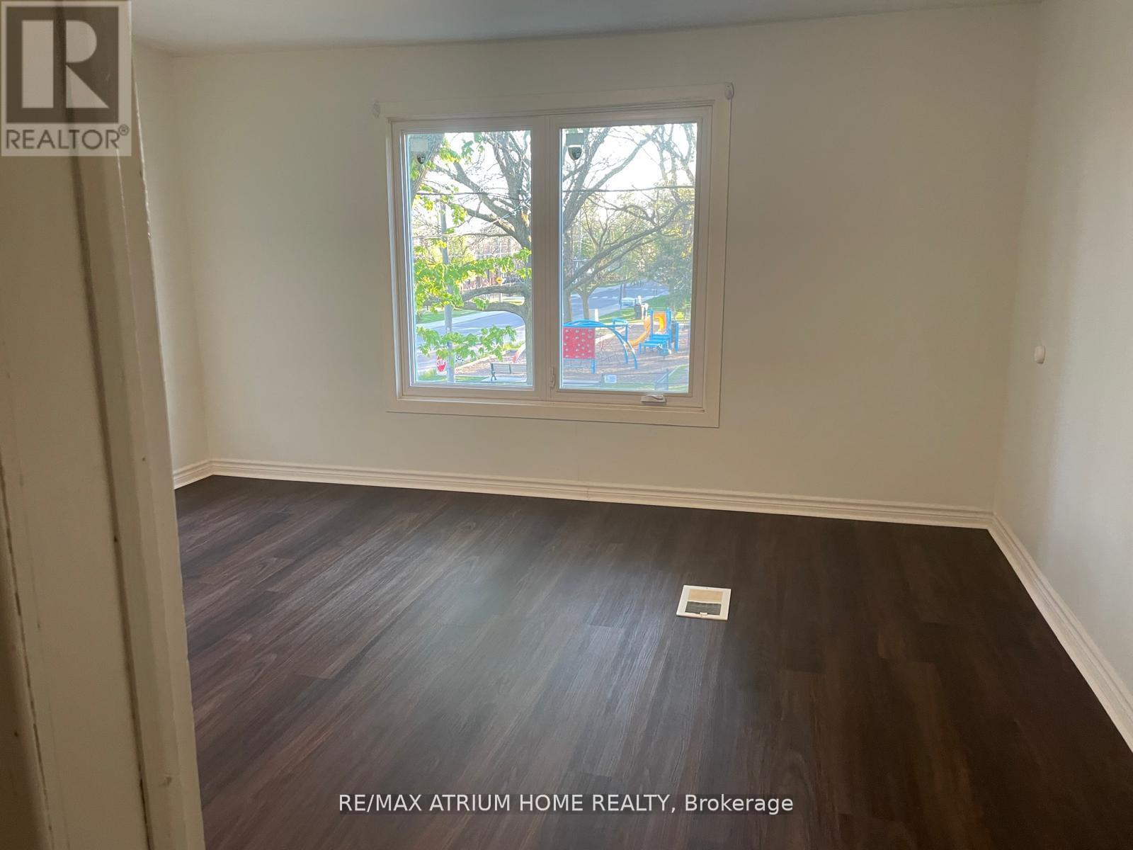 A room with a window showing a view of a playground.