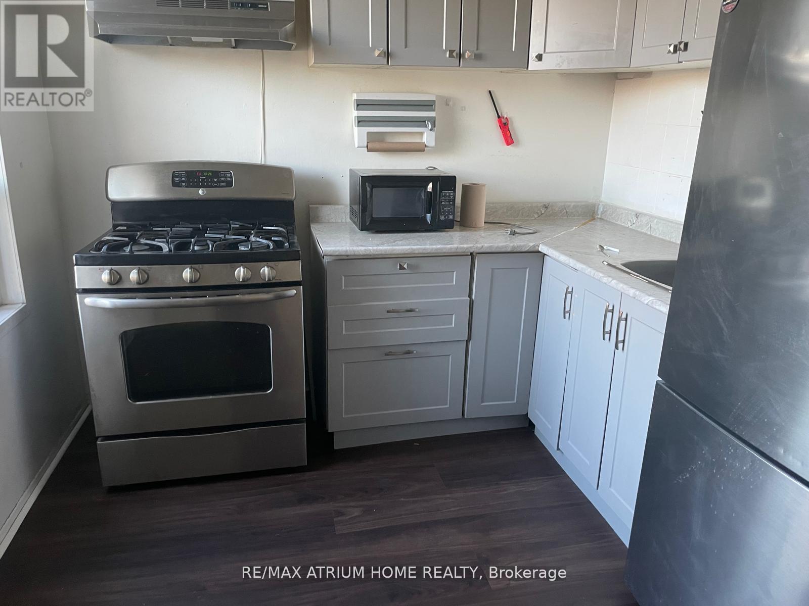 A kitchen with a stove, microwave, and refrigerator.