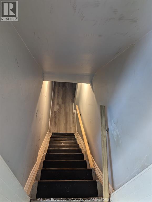 A staircase with wooden steps and white walls.