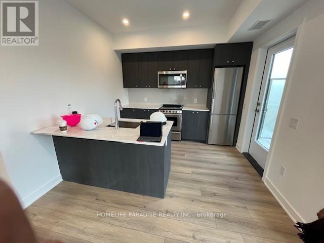 A modern kitchen with a laptop on the island.