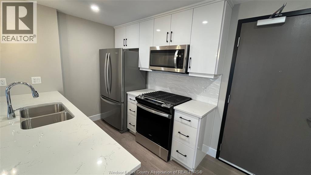 A kitchen with white cabinets and a sink.