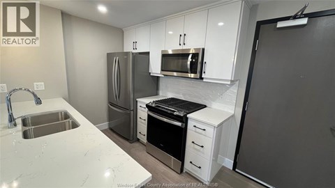 A kitchen with white cabinets and a sink.