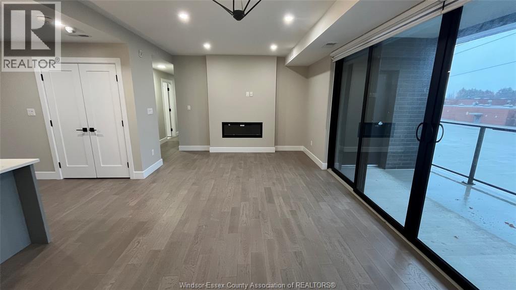 A well-lit, spacious room with a fireplace and sliding glass doors.