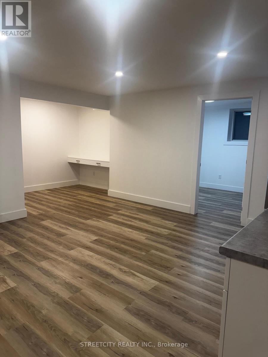 A room with wooden flooring and white walls.
