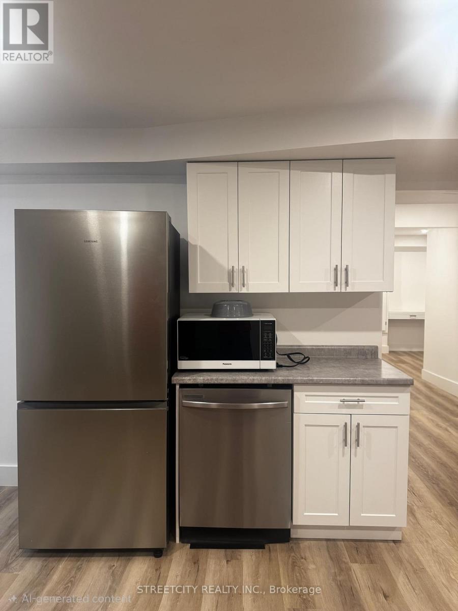 A modern kitchen with a stainless steel refrigerator and white cabinets.