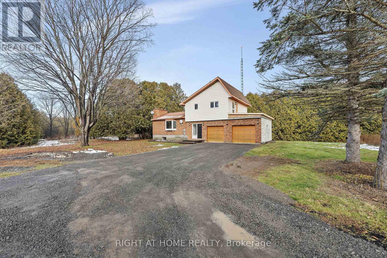 A house with a gravel driveway in front of it.