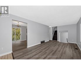 A spacious room with wooden flooring and white walls, with a door leading to a balcony.