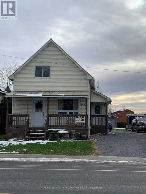A house with a "For Rent" sign in front of it.