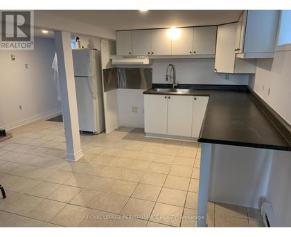 A kitchen with white cabinets and a black countertop.