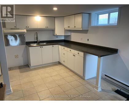 A kitchen with white cabinets and a black countertop.