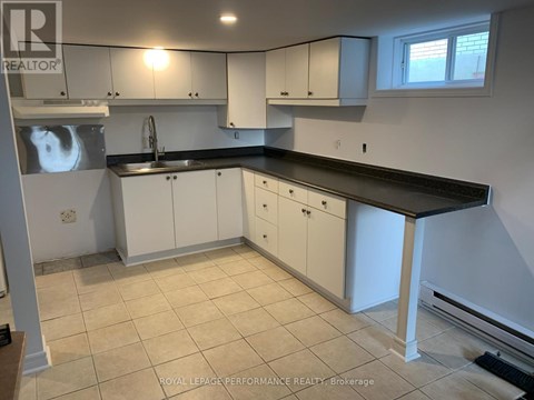 A kitchen with white cabinets and a black countertop.