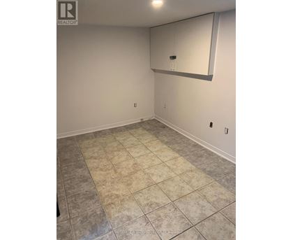 A room with a tile floor and a mirror on the wall.