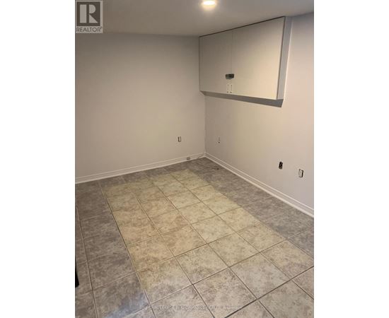 A room with a tile floor and a mirror on the wall.