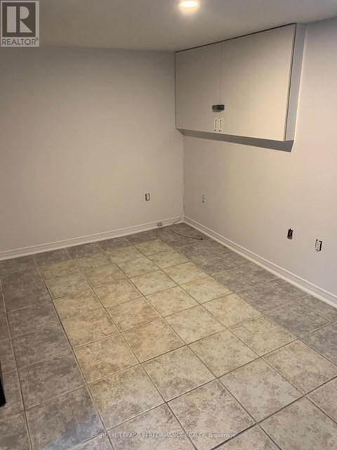 A room with a tile floor and a mirror on the wall.