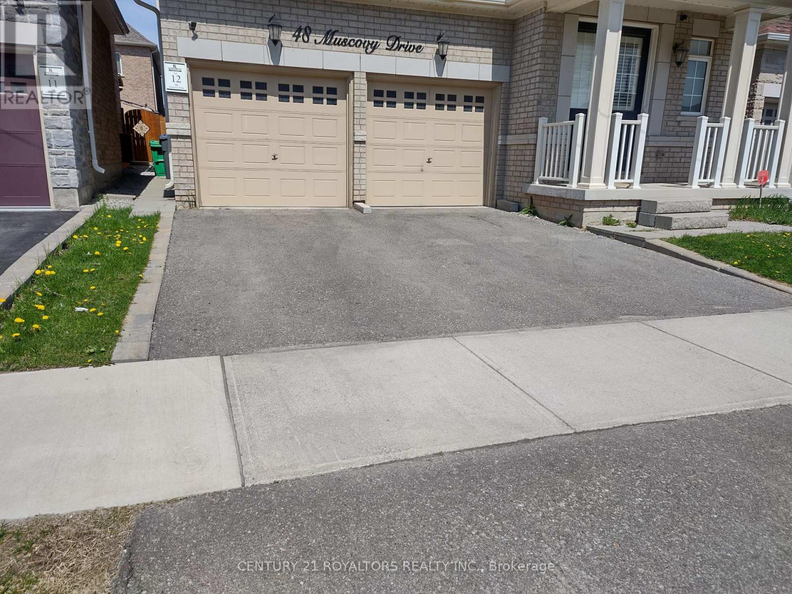 A house with a garage and a driveway in front.