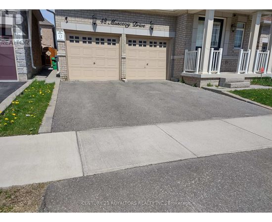 A house with a garage and a driveway in front.