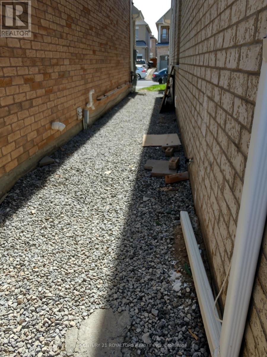 A gravel pathway between two brick walls.