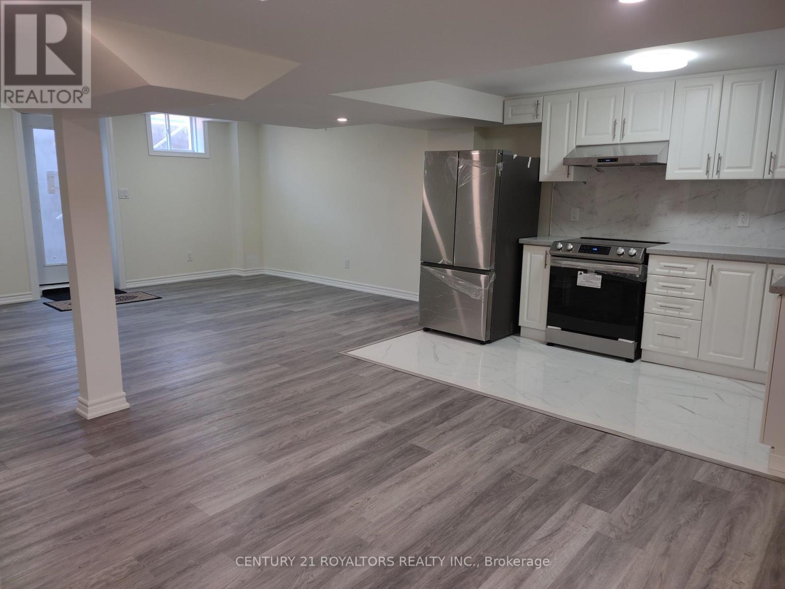 A kitchen with a refrigerator and stove top oven.