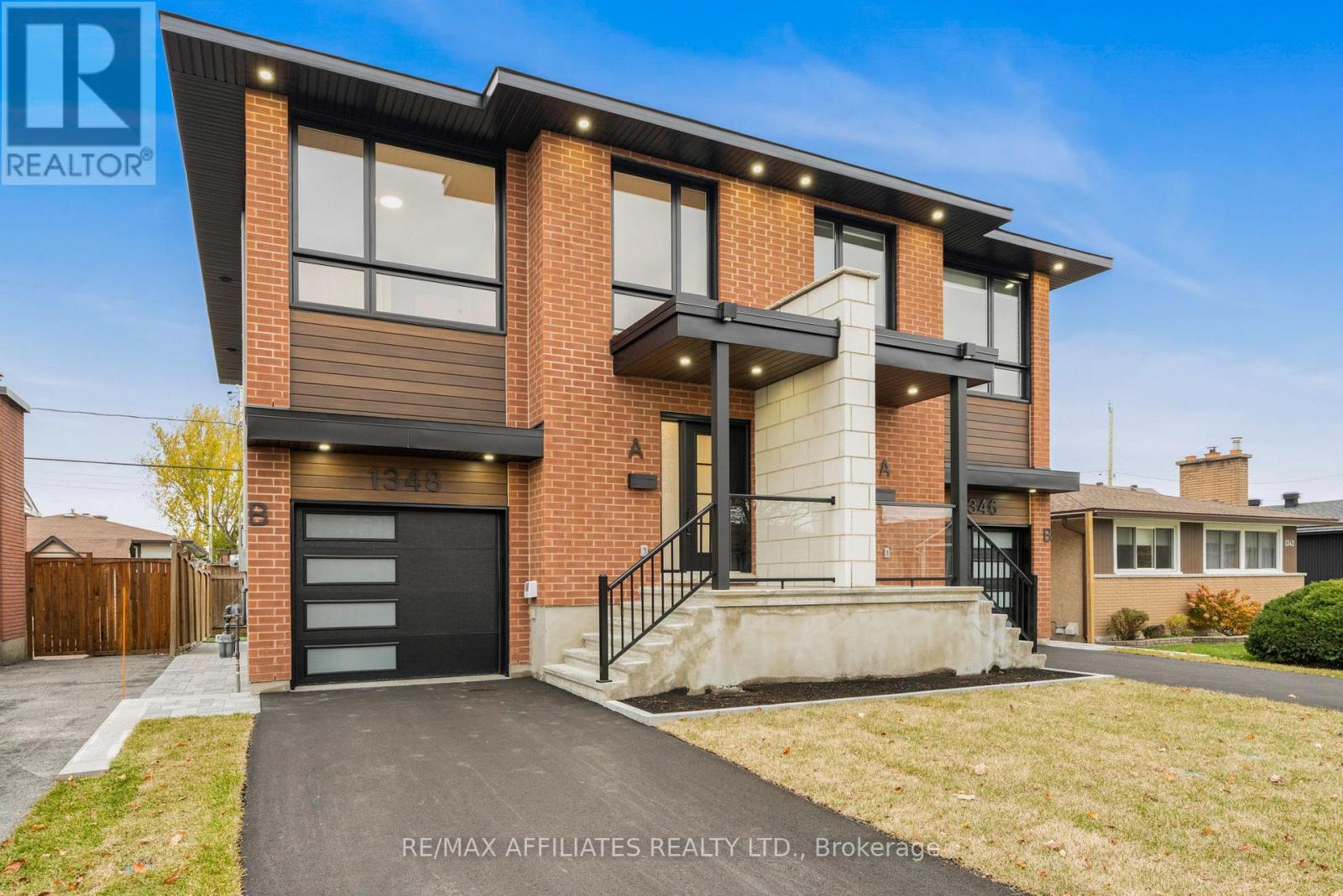 A modern two-story house with a black garage door is for sale.
