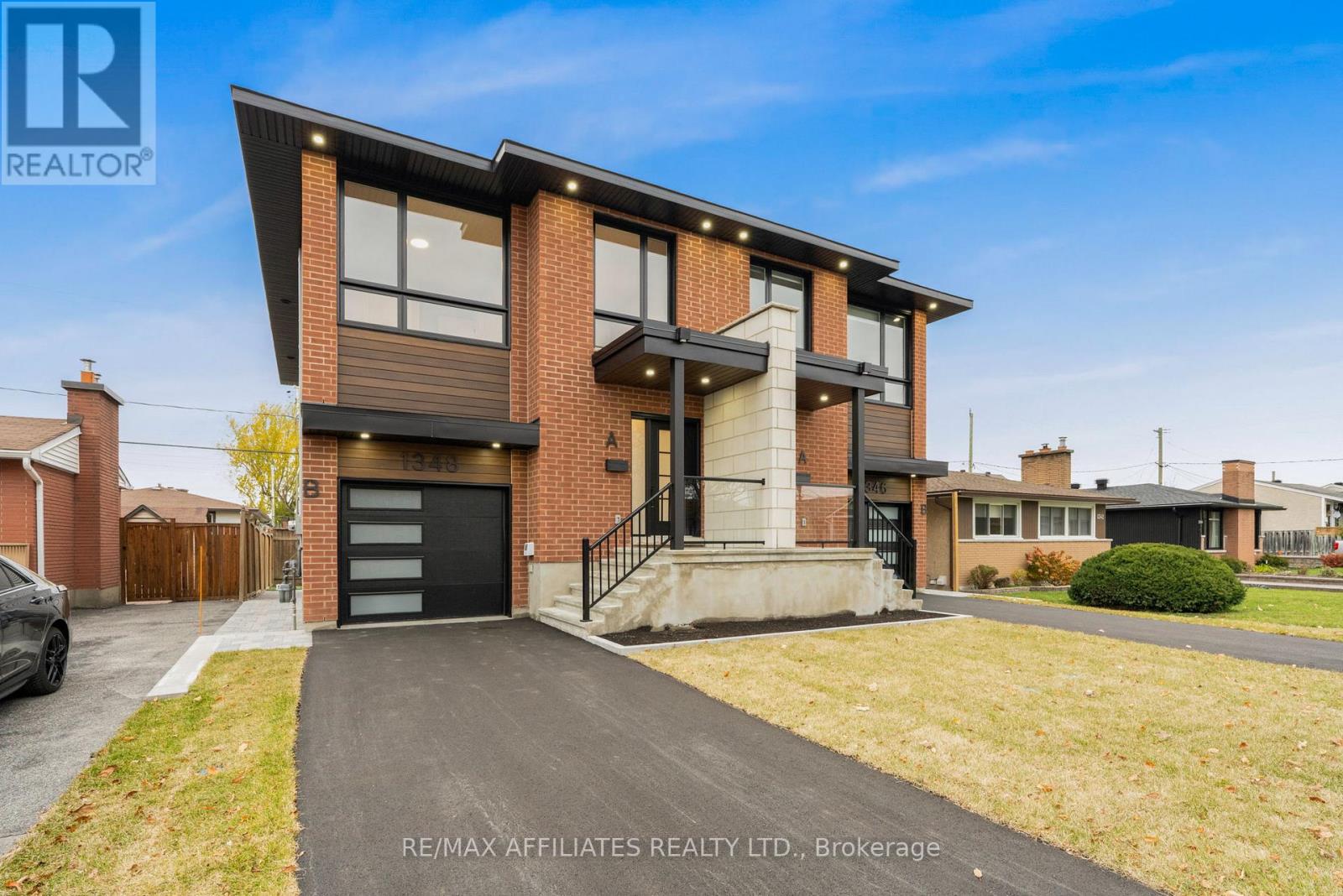 A modern two-story house with a brick facade and a black garage door.