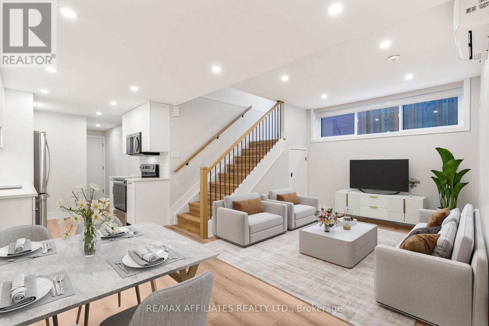 A well-lit, modern living room with a staircase leading to the upper floor.