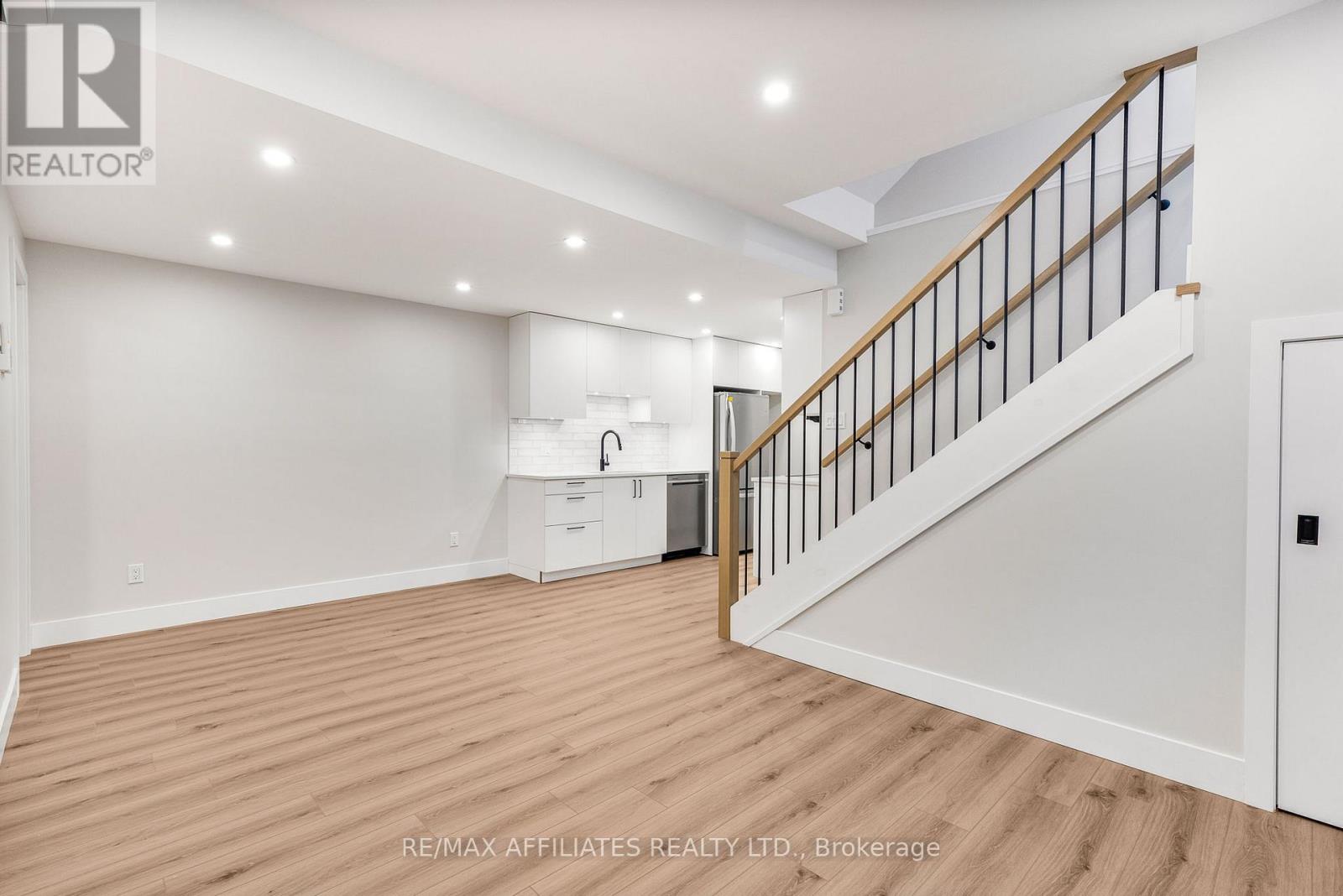 A spacious room with a staircase leading to the upper floor.