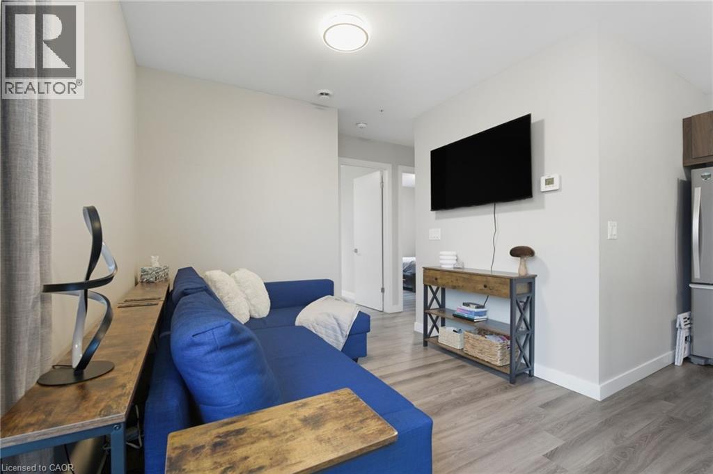A living room with a blue couch and a television mounted on the wall.