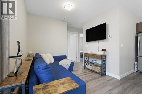A living room with a blue couch and a television mounted on the wall.