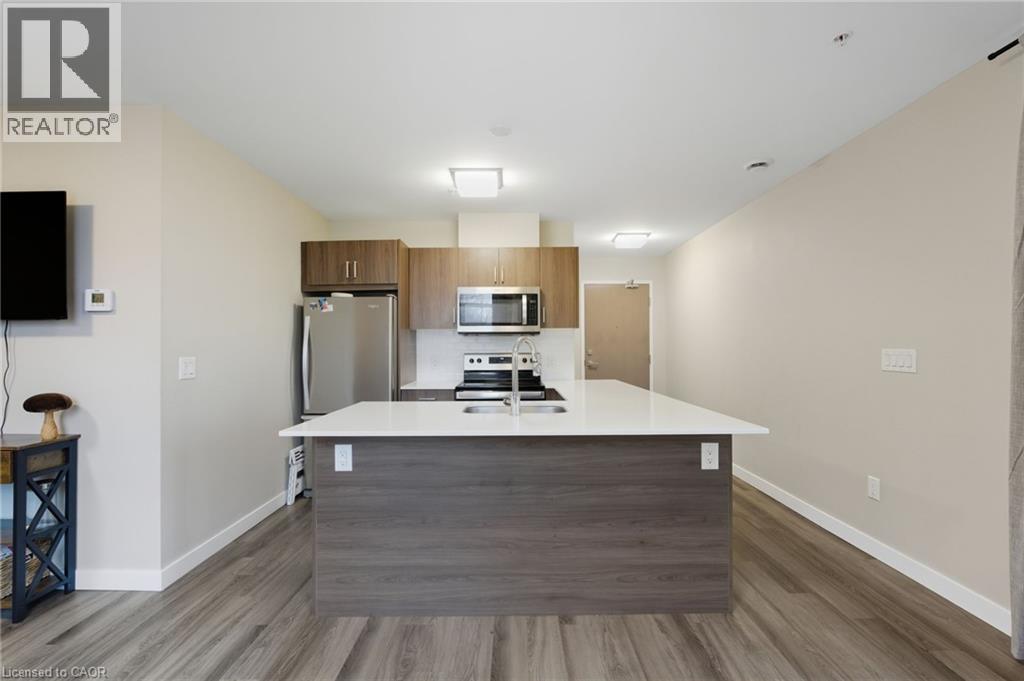 A modern kitchen with a wooden island and stainless steel appliances.
