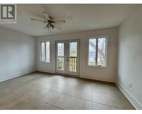 A spacious room with a ceiling fan and sliding glass doors.