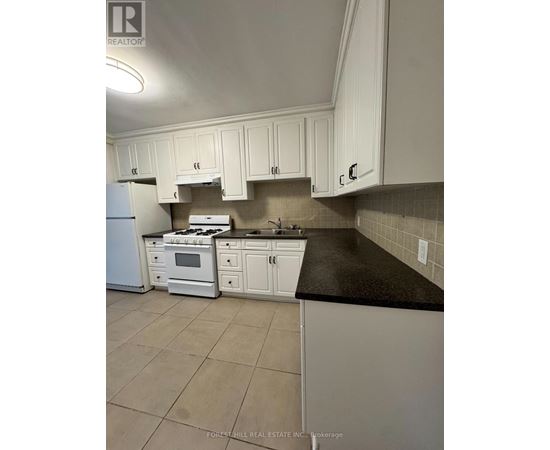 A kitchen with white cabinets and appliances.