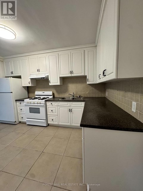 A kitchen with white cabinets and appliances.