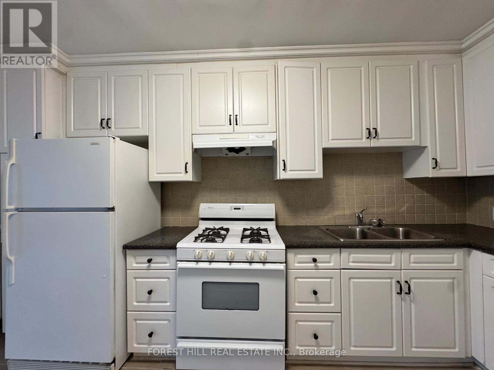A kitchen with white cabinets and appliances.