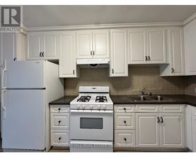 A kitchen with white cabinets and appliances.