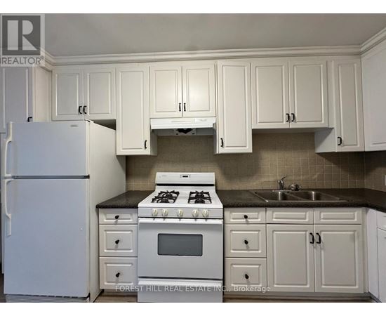 A kitchen with white cabinets and appliances.