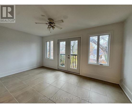 A room with a ceiling fan and tiled flooring.