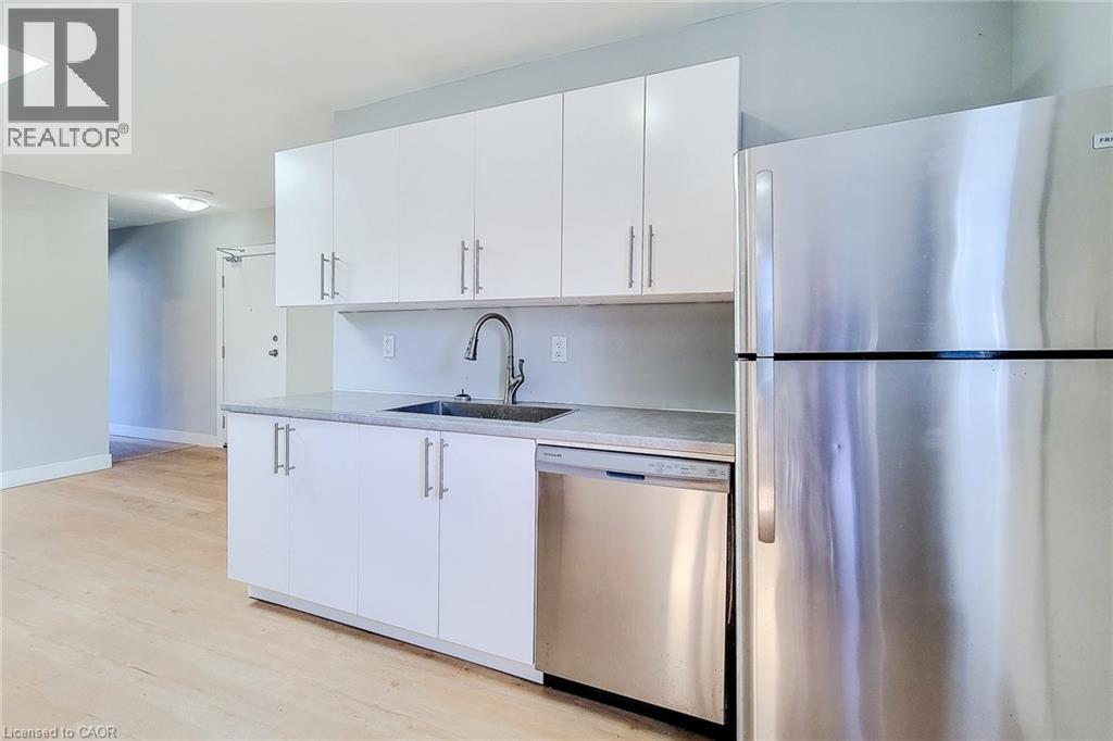 A modern kitchen with white cabinets and stainless steel appliances.
