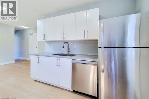 A modern kitchen with white cabinets and stainless steel appliances.