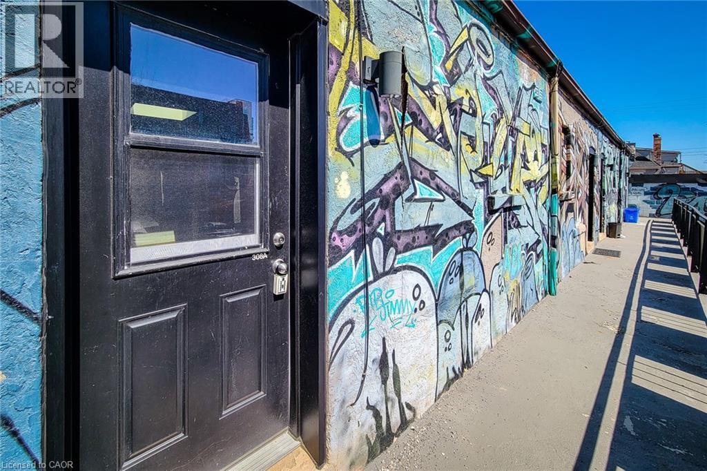 A wall covered in graffiti with a door on the left.