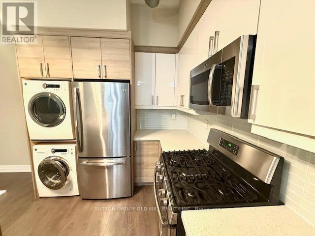 A kitchen with a stainless steel refrigerator, oven, and microwave.