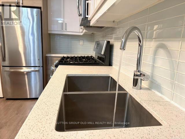 A kitchen with a stainless steel refrigerator and a sink.