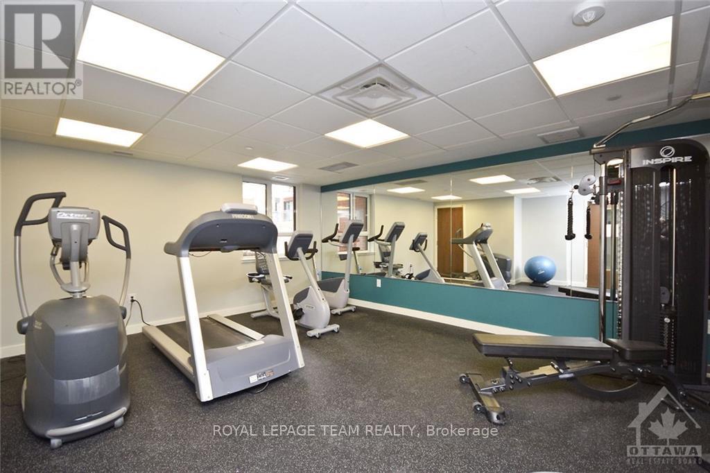 A gym room with a treadmill, weights, and exercise equipment.