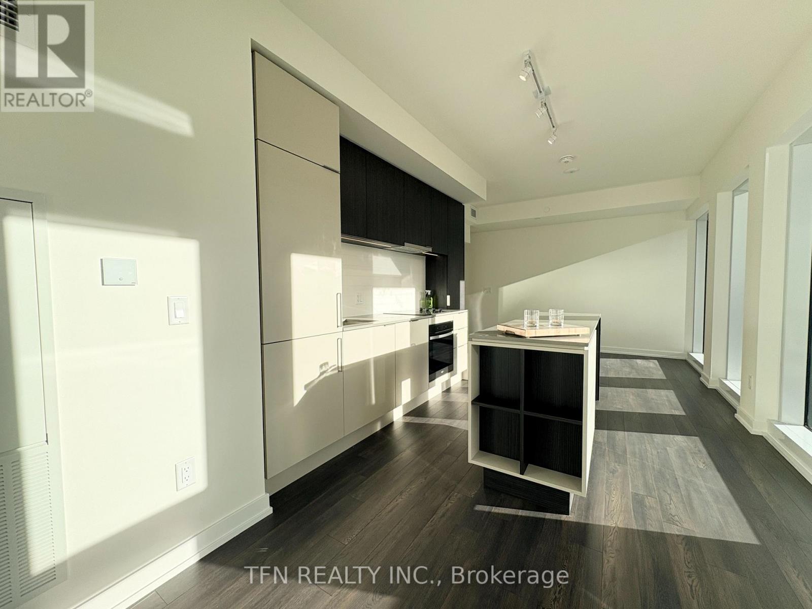 A modern kitchen with white cabinets and a black countertop.