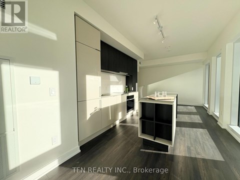 A modern kitchen with white cabinets and a black countertop.