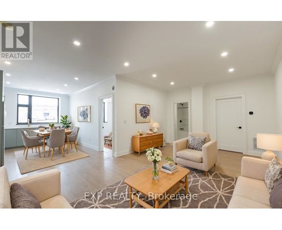 A well-lit, spacious living room with a dining area in the background.