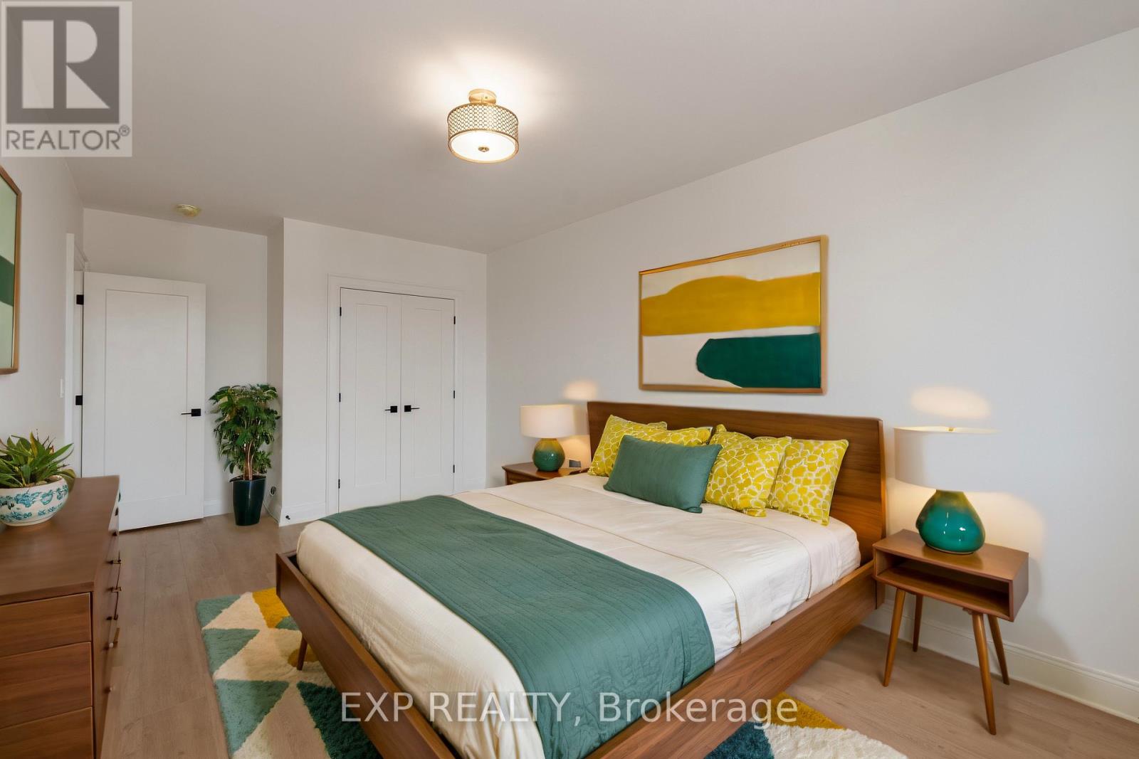 A bedroom with a bed, nightstand, and lamp.