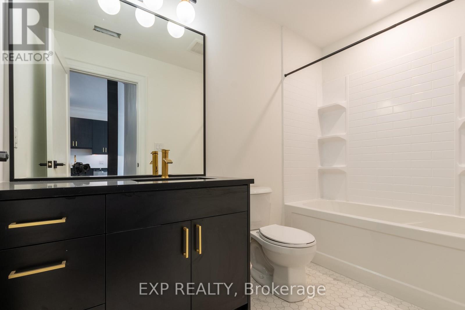 A bathroom with a black vanity and a white toilet.