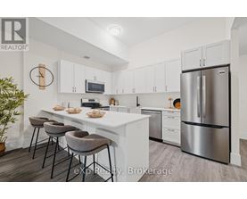A kitchen with white cabinets and a stainless steel refrigerator.